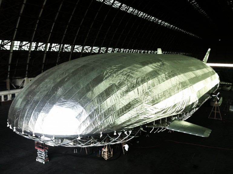 The massive aircraft is dwarfed by the even larger blimp hangar