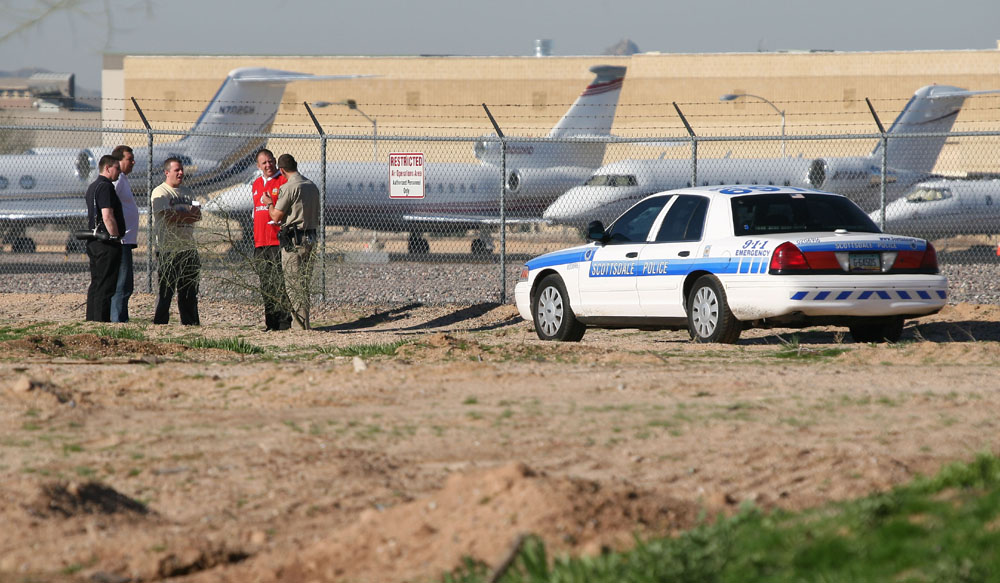 A group of UK plane spotters engaging with local law enforcement in Arizona. This shot was taken at Scottsdale airport, in Phoenix, in February 2008, and was during the weekend that the city hosted the Superbowl. Significant sporting events such as this attract the wealthy and famous, and local airfields are crammed with private jets, parked row upon row. Naturally an attraction for spotters and photographers alike, many enthusiasts will arrange vacation plans to attend this kind of event. In this case the police used the ideal approach - they came along and said hello, they checked out who we are, what we were doing and politely set the boundaries. In this case, we were asked not to go right up to the fence - keep a little distance so as not to alarm the locals or passengers. So the other side of the road where I was stood was perfect for landing shots and watching the action, and provided a situation where every one was happy. 